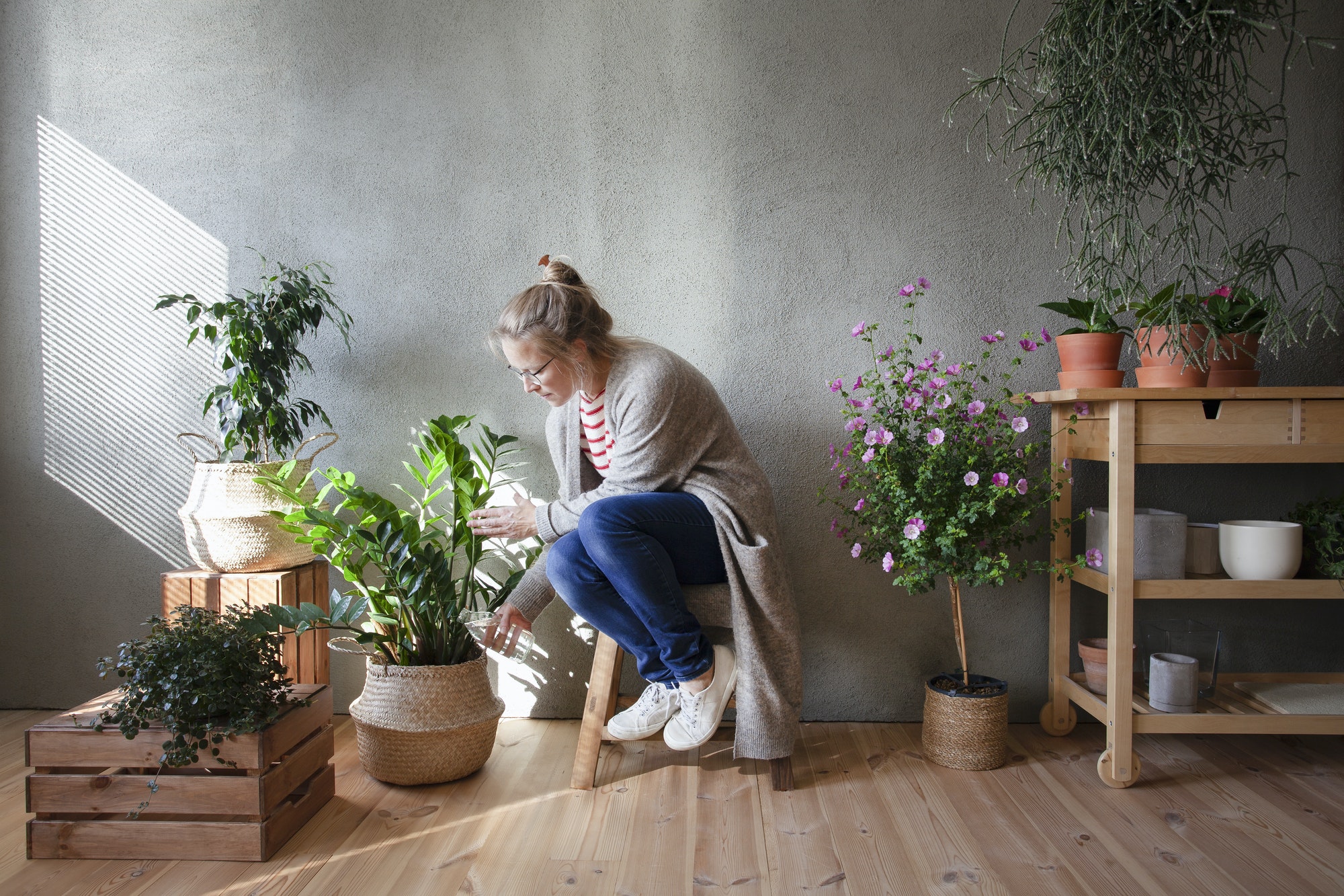 Woman tending to potted plants in indoor garden